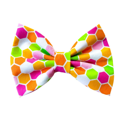 Colorful geometric patterned bow on a light pink background
