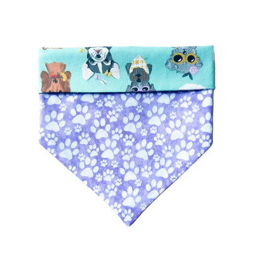Dog bandana with cartoon characters on a blue background and paw prints on a purple background.